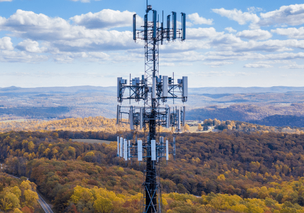 A cell tower standing tall against a backdrop of a road, providing seamless connectivity to users.