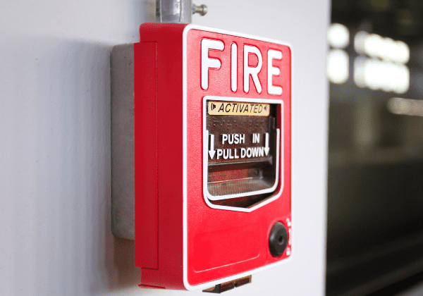 A red fire alarm mounted on the wall, ready to be activated in case of an emergency.